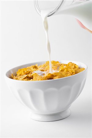 pour milk in cereal - Pouring milk on cornflakes Stock Photo - Premium Royalty-Free, Code: 659-03536577