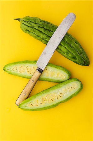 Melon amer entière ou coupées en deux avec le couteau sur fond jaune Photographie de stock - Premium Libres de Droits, Code: 659-03536582