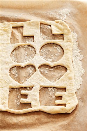 Biscuit dough with the word 'LOVE' cut out twice Stock Photo - Premium Royalty-Free, Code: 659-03536702