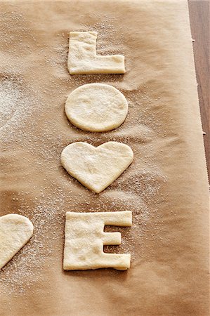 simsearch:659-03536702,k - Cut-out 'LOVE' biscuits on baking parchment Stock Photo - Premium Royalty-Free, Code: 659-03536703