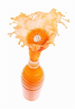 simsearch:659-06306568,k - Mandarin orange juice splashing out of bottle Fotografie stock - Premium Royalty-Free, Codice: 659-03536737