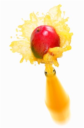 Mango juice splashing out of bottle Stock Photo - Premium Royalty-Free, Code: 659-03536738