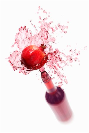 punica granatum - Pomegranate juice splashing out of bottle Stock Photo - Premium Royalty-Free, Code: 659-03536733