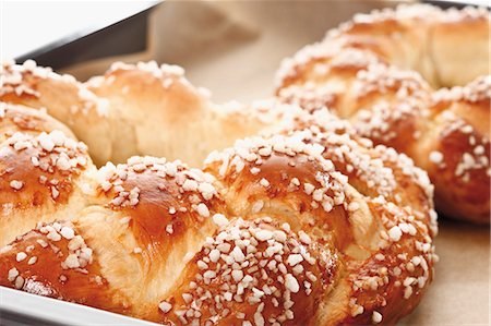 Bread wreaths with pearl sugar on baking tray (close-up) Stock Photo - Premium Royalty-Free, Code: 659-03536841