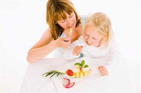 simsearch:659-03535510,k - Mother and daughter eating fruit from plate Foto de stock - Sin royalties Premium, Código: 659-03536930