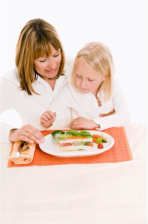 simsearch:659-03536938,k - Mother & daughter sitting at table in front of vegetable terrine Fotografie stock - Premium Royalty-Free, Codice: 659-03536931
