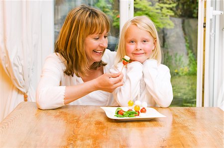 family cheese - Mother & daughter eating mozzarella & tomatoes on cocktail sticks Stock Photo - Premium Royalty-Free, Code: 659-03536940
