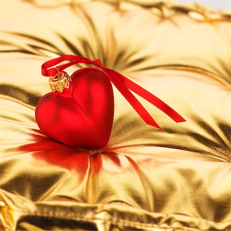 Red heart (tree ornament) on gold cushion Stock Photo - Premium Royalty-Free, Code: 659-03536971