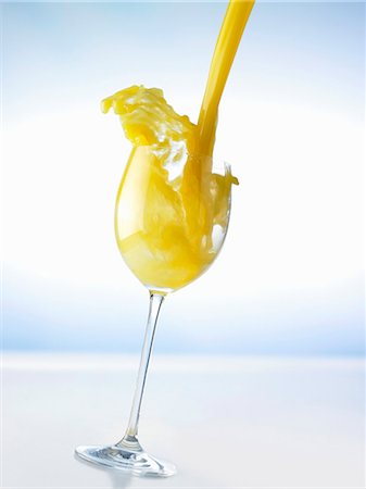 Pouring orange juice into a glass (splash) Stock Photo - Premium Royalty-Free, Code: 659-03537020