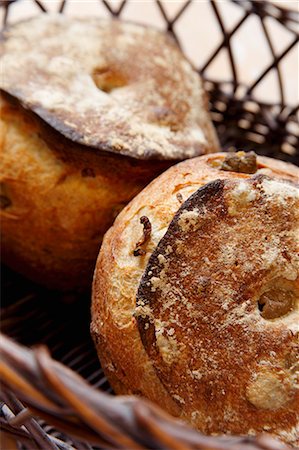 simsearch:659-03537037,k - Two Green Olive Levain Loaves in a Basket Foto de stock - Royalty Free Premium, Número: 659-03537036