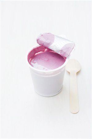plastic tumbler - Fruit yoghurt in opened pot, wooden spoon beside it Stock Photo - Premium Royalty-Free, Code: 659-03537242
