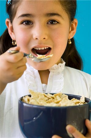 Girl eating cornflakes Stock Photo - Premium Royalty-Free, Code: 659-03537409