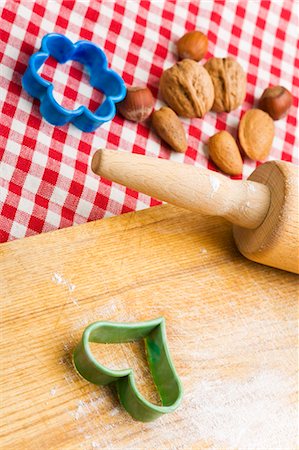 Rolling pin, biscuit cutters and nuts with wooden board Foto de stock - Sin royalties Premium, Código: 659-03537593