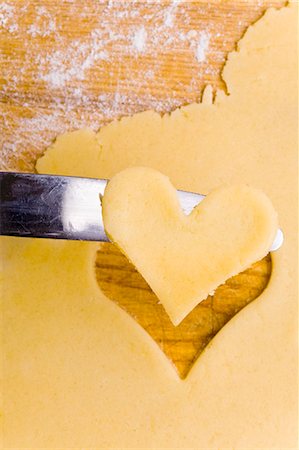 Cut-out heart-shaped biscuit on knife Stock Photo - Premium Royalty-Free, Code: 659-03537603