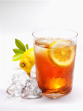 Glass of iced tea with lemon and ice cubes Foto de stock - Sin royalties Premium, Código: 659-03537647