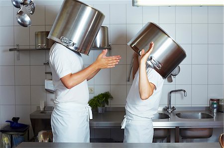 Two chefs having discussion with large pans on their heads Stock Photo - Premium Royalty-Free, Code: 659-03537666