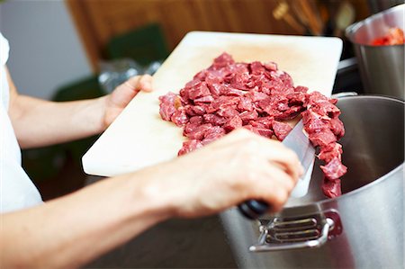 Chef tipping chopped beef into a pan Stock Photo - Premium Royalty-Free, Code: 659-03537672