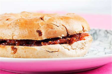 Cinnamon and raisin bagel with fig jam (close-up) Stock Photo - Premium Royalty-Free, Code: 659-03537813