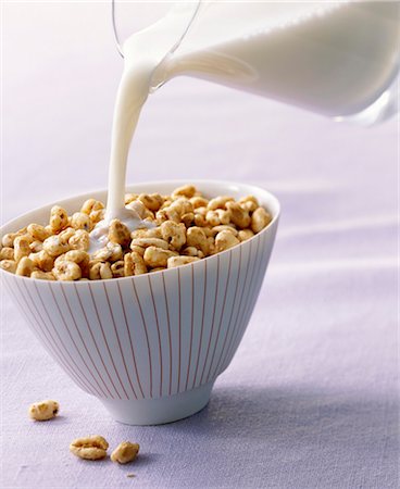 pouring milk and honey - Pouring milk onto honey puffed wheat breakfast cereal Stock Photo - Premium Royalty-Free, Code: 659-03530020