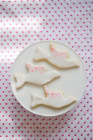 Trois biscuits Dove avec glaçage blanc et rose Photographie de stock - Premium Libres de Droits, Code: 659-03530278