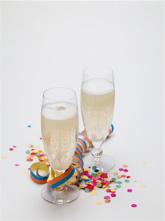 Deux verres de vin mousseux, banderoles de papier et confetti Photographie de stock - Premium Libres de Droits, Code: 659-03530470