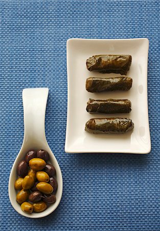 Stuffed vine leaves on plate, olives on spoon Stock Photo - Premium Royalty-Free, Code: 659-03530509