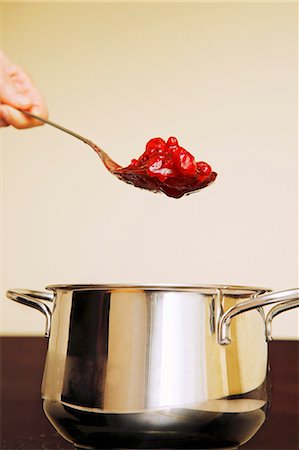 stewed fruit - Hand holding a spoonful of red berry compote over a pan Stock Photo - Premium Royalty-Free, Code: 659-03530514