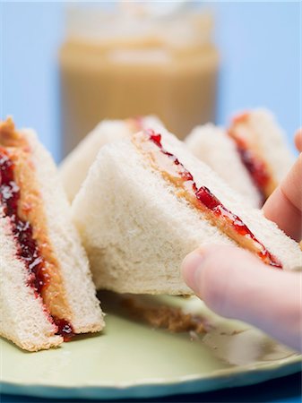 peanut butter - Hand reaching for peanut butter and jelly sandwich Stock Photo - Premium Royalty-Free, Code: 659-03530529