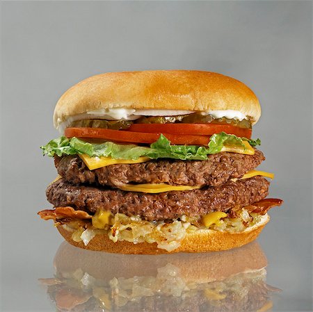 double cheeseburger - Double Cheeseburger with Bacon, Lettuce, Tomato and Pickles Stock Photo - Premium Royalty-Free, Code: 659-03530558