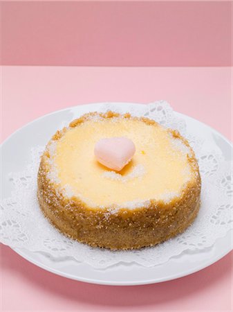 Small cheesecake with sugar heart on plate with doily Stock Photo - Premium Royalty-Free, Code: 659-03530662