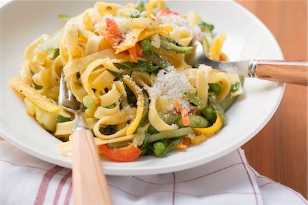 Tagliatelle primavera with vegetables & grated cheese on plate Stock Photo - Premium Royalty-Free, Code: 659-03530732