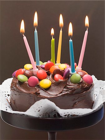 Chocolate cake with coloured chocolate beans and candles Stock Photo - Premium Royalty-Free, Code: 659-03530881