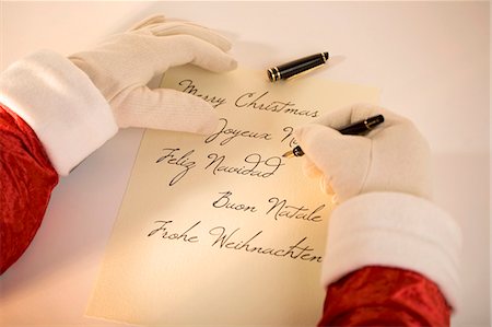 penna stilografica - Father Christmas writing Merry Christmas in several languages Fotografie stock - Premium Royalty-Free, Codice: 659-03530956