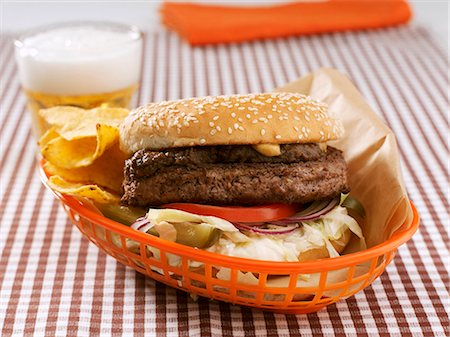 Hamburger and crisps in plastic basket, glass of beer Stock Photo - Premium Royalty-Free, Code: 659-03530974