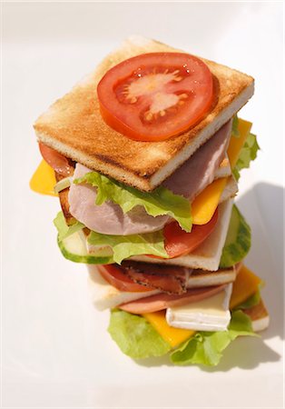 Tower of toast, ham, sausage, cheese, tomatoes and lettuce Stock Photo - Premium Royalty-Free, Code: 659-03530992