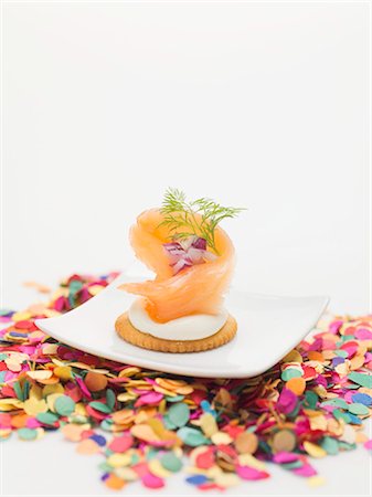 Smoked salmon on cracker on plate surrounded by confetti Stock Photo - Premium Royalty-Free, Code: 659-03531015