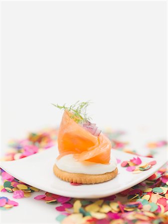 Smoked salmon on cracker on plate surrounded by confetti Stock Photo - Premium Royalty-Free, Code: 659-03531018