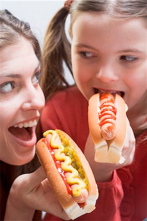 people eating hot dogs - Woman and girl eating hot dogs together Stock Photo - Premium Royalty-Free, Code: 659-03531199