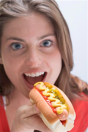 Femme manger un hot dog à la moutarde Photographie de stock - Premium Libres de Droits, Code: 659-03531200