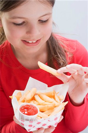 french fry smile - Girl eating a bag of chips Stock Photo - Premium Royalty-Free, Code: 659-03531216