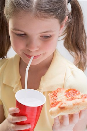 eaten - Girl holding slice of pizza and drinking Foto de stock - Sin royalties Premium, Código: 659-03531229