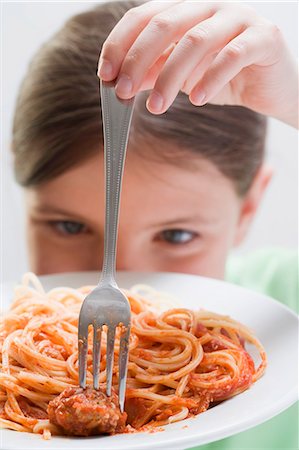 spaghetti & meatball - Girl spearing a meatball on a fork Stock Photo - Premium Royalty-Free, Code: 659-03531235