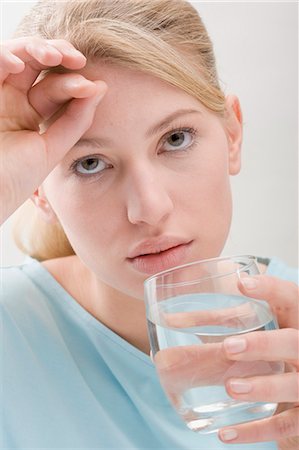 simsearch:659-03534820,k - Femme avec maux de tête verre d'eau à boire Photographie de stock - Premium Libres de Droits, Code: 659-03531854