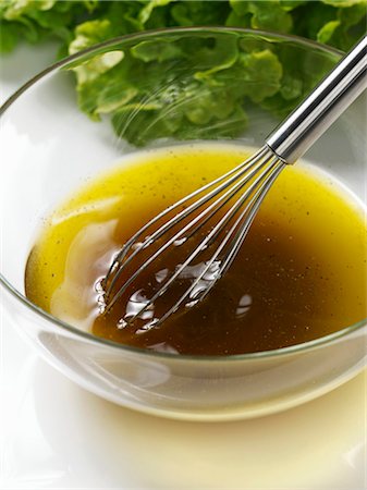 Salad dressing (vinaigrette) in glass dish with whisk Fotografie stock - Premium Royalty-Free, Codice: 659-03531875