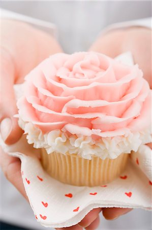 Hands holding cupcake with marzipan rose Foto de stock - Sin royalties Premium, Código: 659-03531963