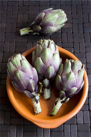 Four baby artichokes with terracotta dish Stock Photo - Premium Royalty-Free, Code: 659-03532000