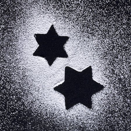 pasteles de navidad - Star shapes in icing sugar on black background Foto de stock - Sin royalties Premium, Código: 659-03532612
