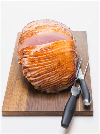 roasted (meat) - Glazed ham on chopping board with carving cutlery Foto de stock - Sin royalties Premium, Código: 659-03532671