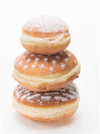 simsearch:659-01854280,k - Three doughnuts dusted with icing sugar, stacked Foto de stock - Royalty Free Premium, Número: 659-03532687