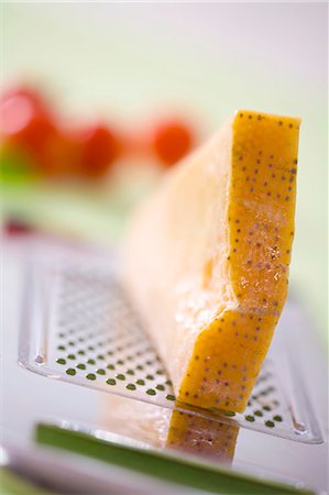 parmesano - A piece of Parmesan on a grater Foto de stock - Sin royalties Premium, Código: 659-03533103